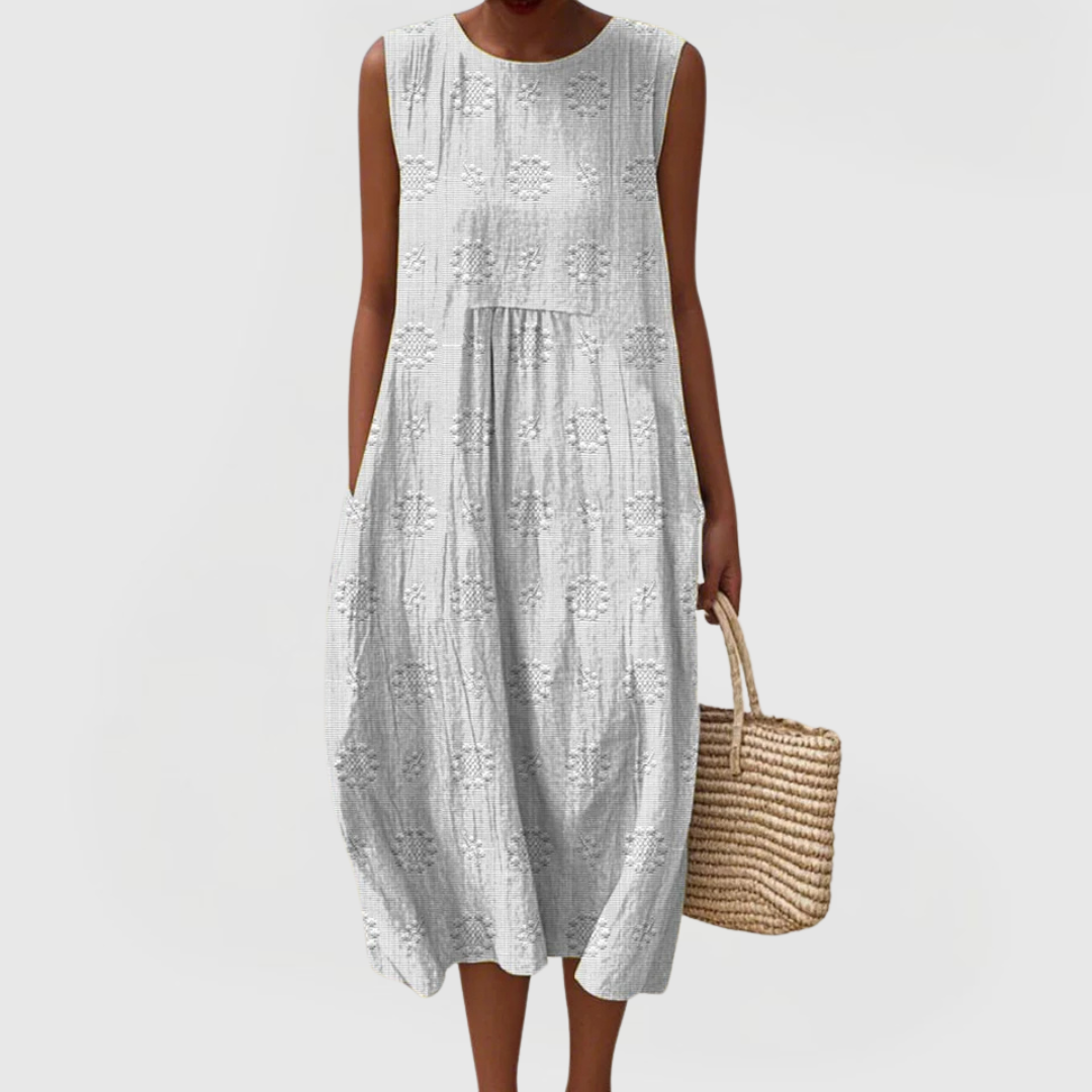 Side profile of sleeveless linen midi dress showing gathered waistline and mid-calf length