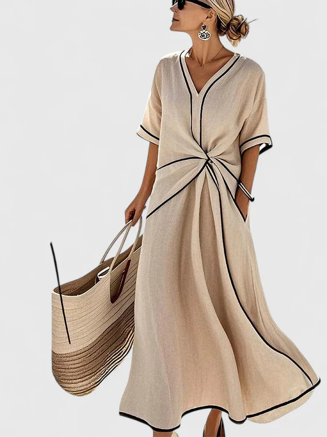 Close-up of V-neckline and short sleeves with black contrast piping on linen dress