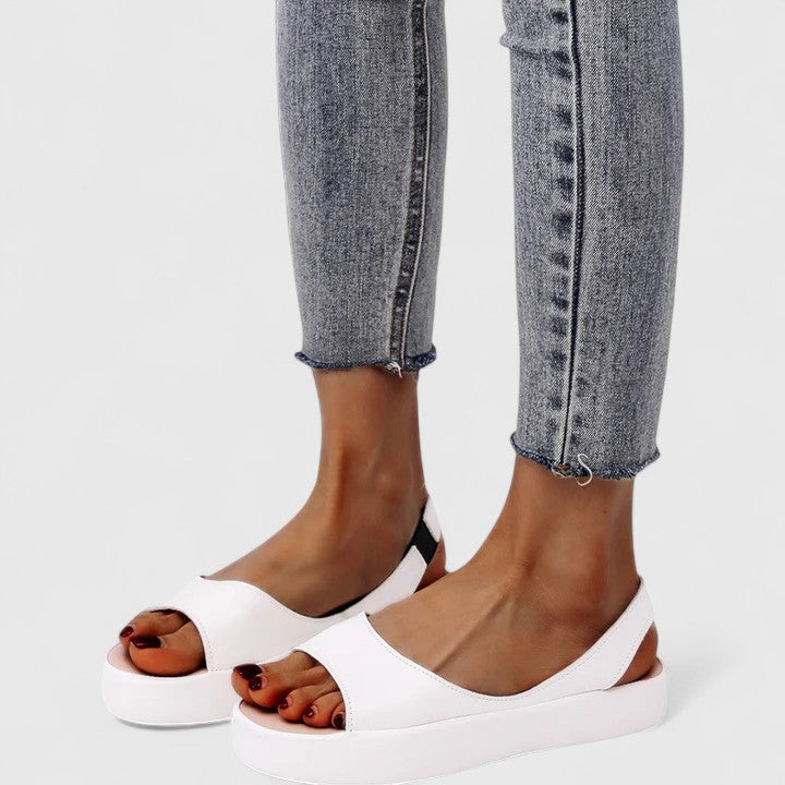 Orange orthopedic sandals showcasing slip-on back strap and contoured sole for stability and support