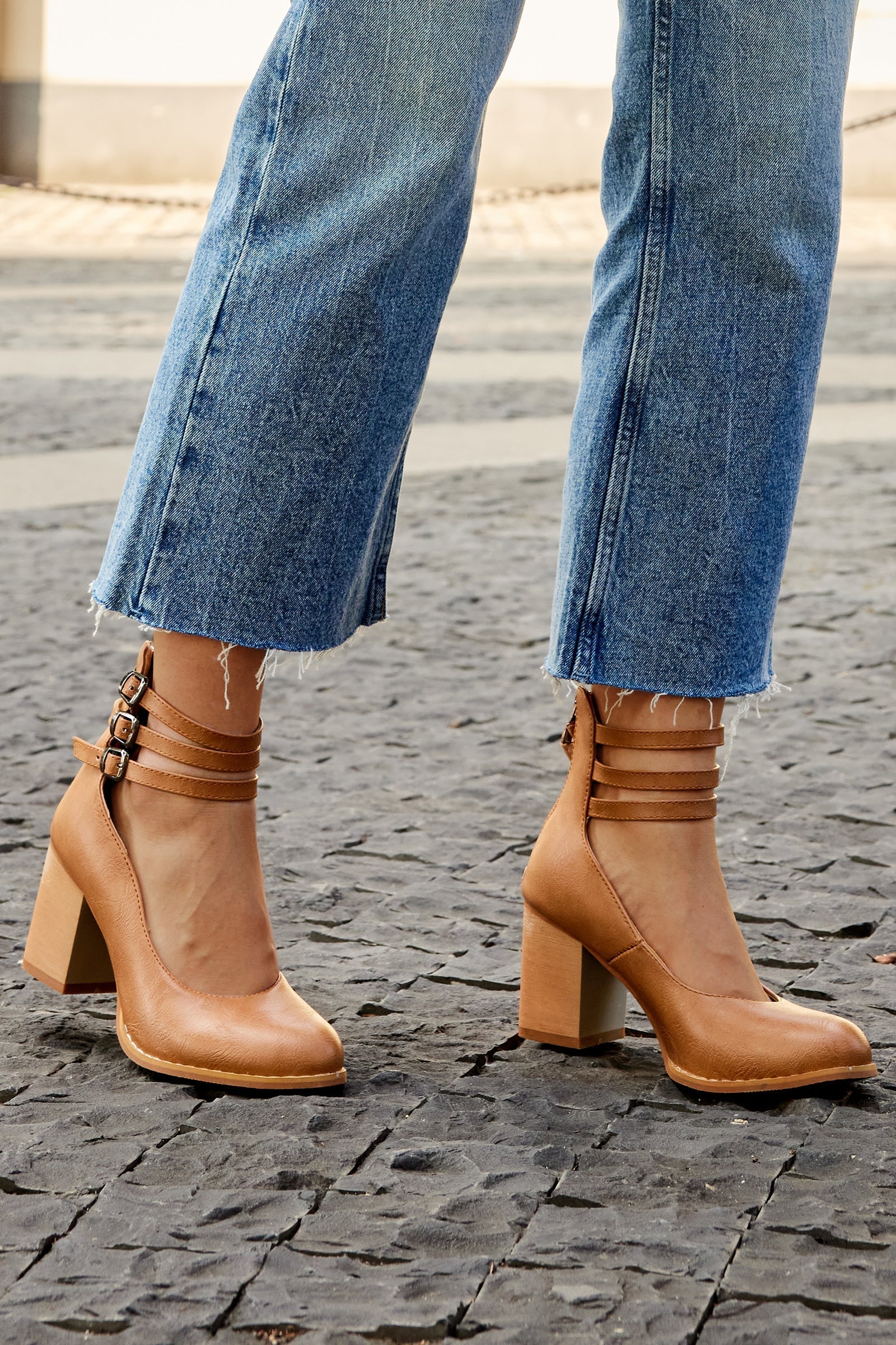 Smooth sandals with ankle strap and thick heel paired with frayed hem jeans