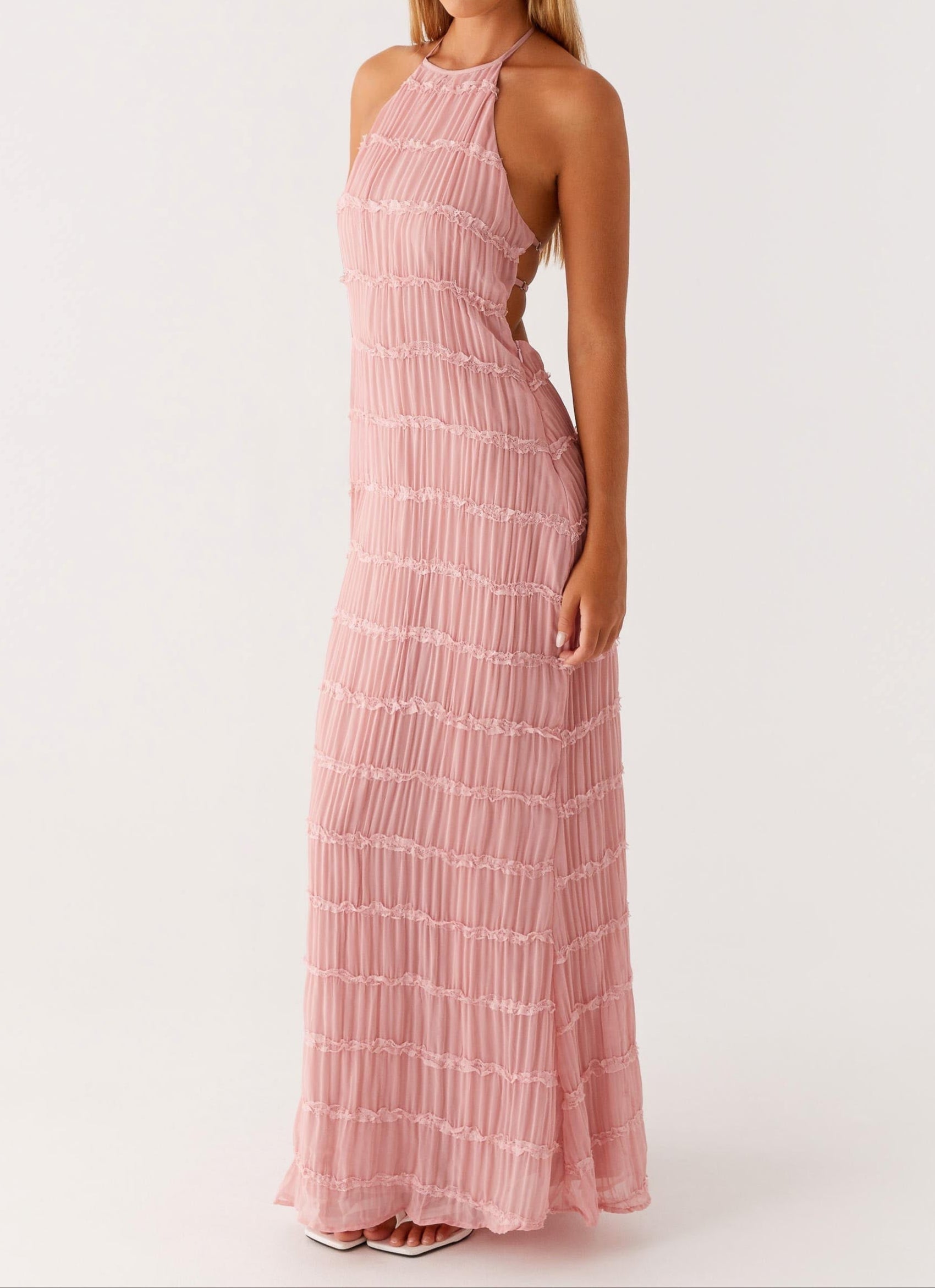 Side view of halter maxi dress showing flowing floor-length silhouette and tiered design