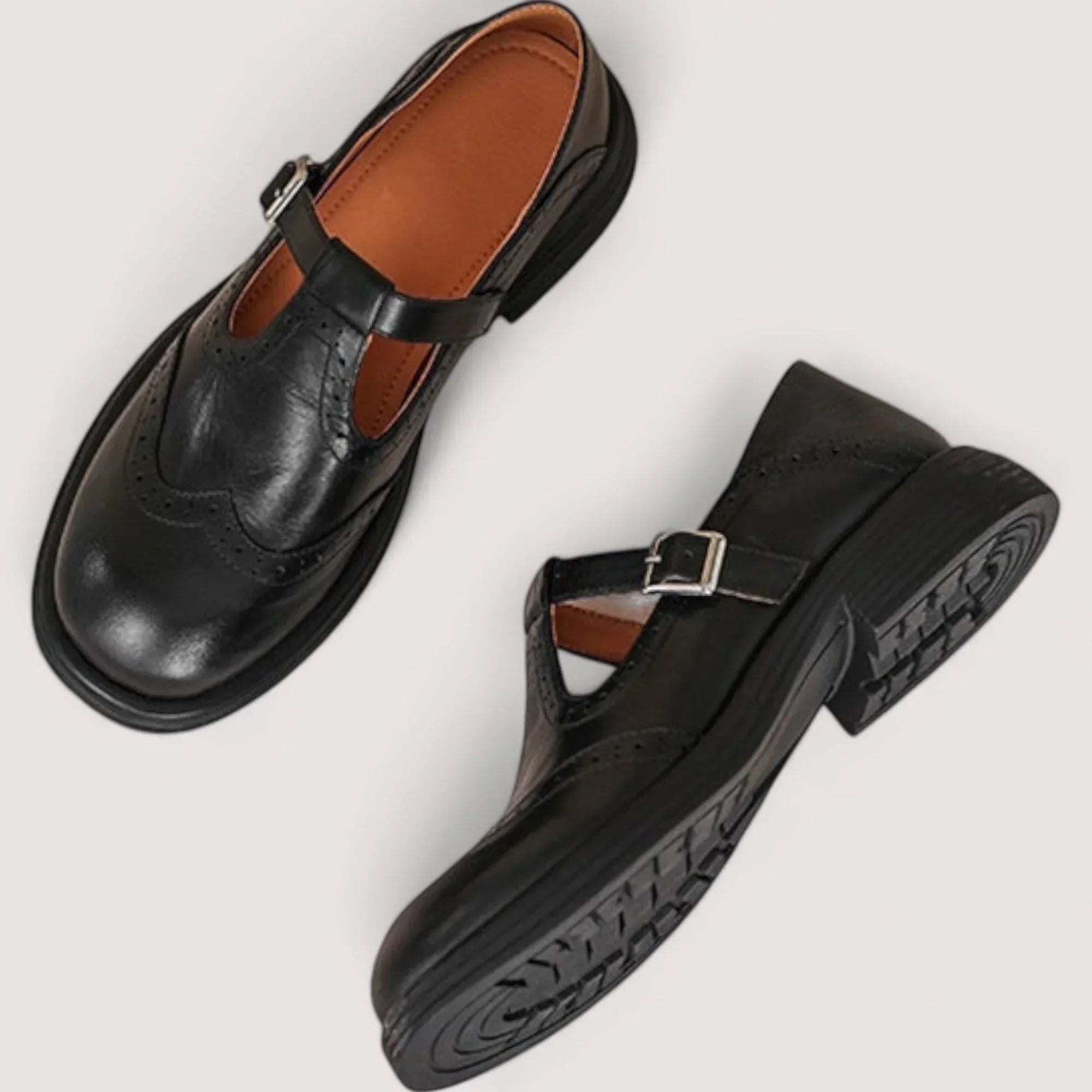Close-up of brown orthopedic mary jane shoes showing rounded toe and decorative perforations on structured upper