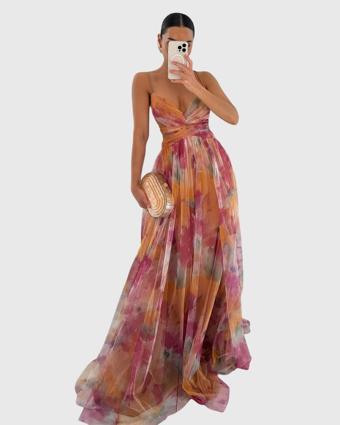 Woman wearing a floral maxi dress with watercolor print in sunset tones and adjustable crisscross straps