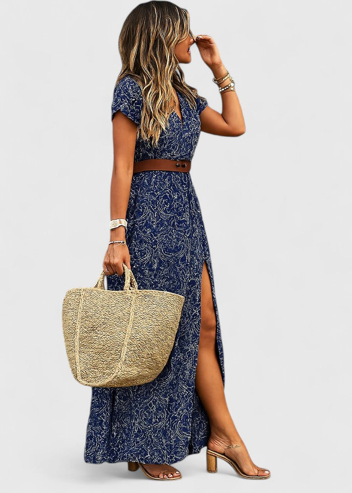 Woman wearing sophisticated maxi dress with boho print, gathered waist, and side slit detail