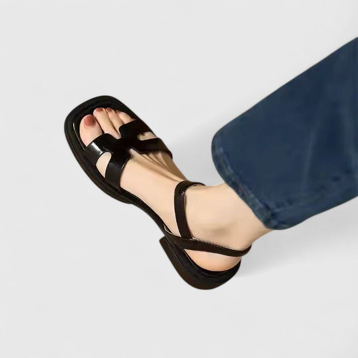 Side view of sophisticated flat sandals showing low block heel and structured footbed construction